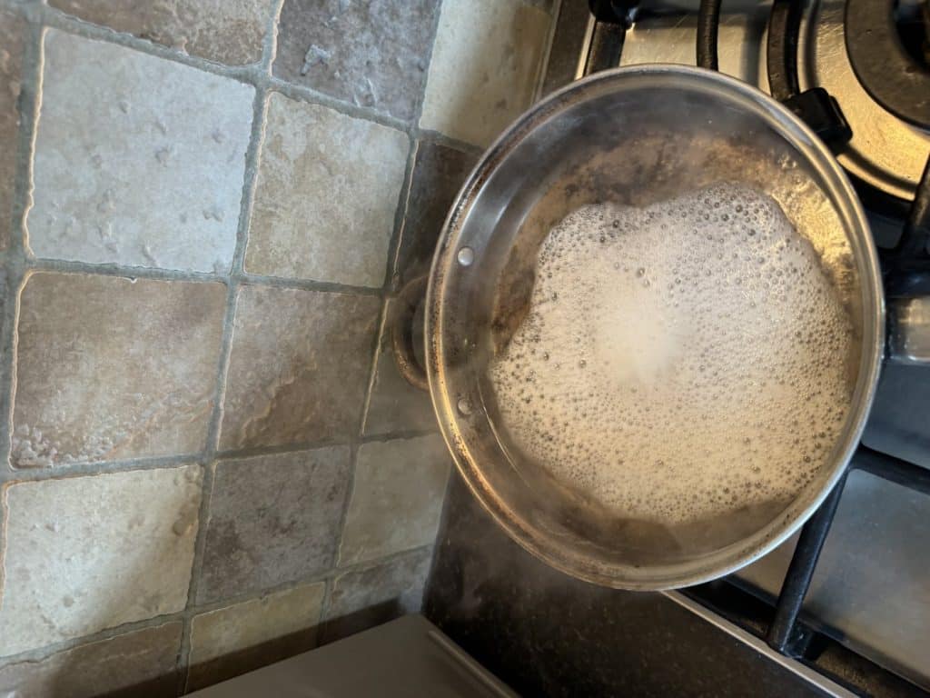Burnt frying pan simmering on the hob with water and bicarbonate of soda