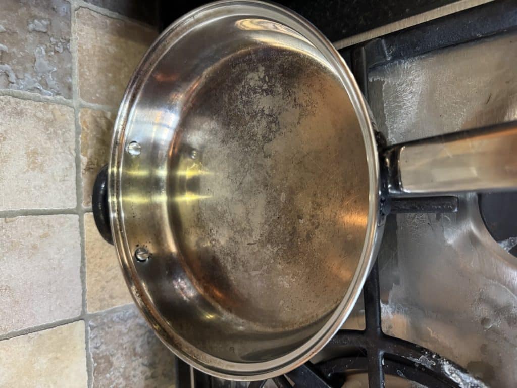 The same stainless steel frying pan cleaned up after bicarbonate of soda and a scourer